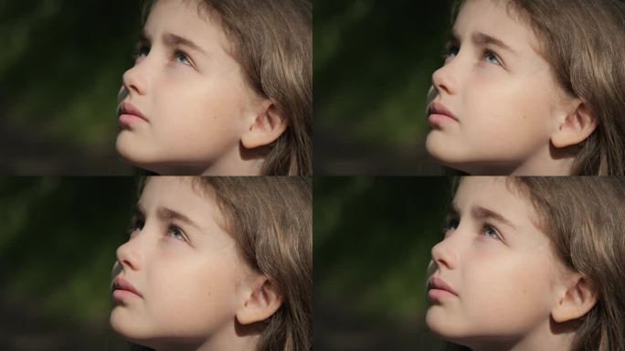 孩子在大自然中仰望天空。肖像少女祈祷仰望天空与希望和信念，沉思的孩子的脸，特写。女孩仰望上帝的信徒祈