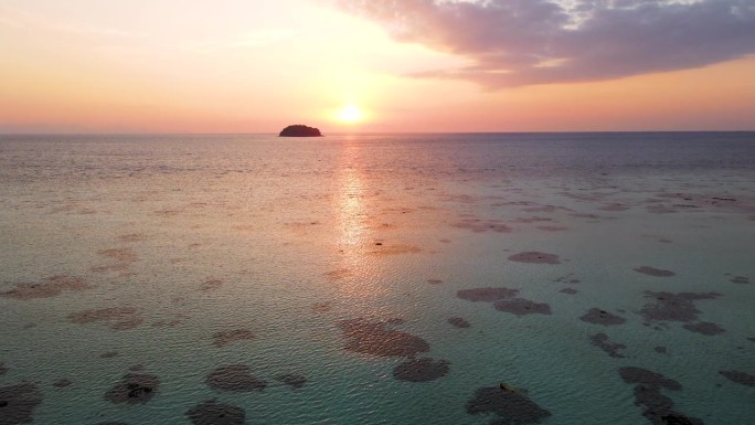 在日落背景下低水位飞越海洋，泰国沙卡通里比岛