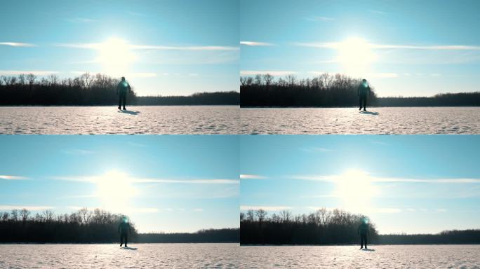 一个男人的剪影在夕阳下穿过雪地走向远方。一个孤独的人走过一片大雪覆盖的草地。失败和孤独。