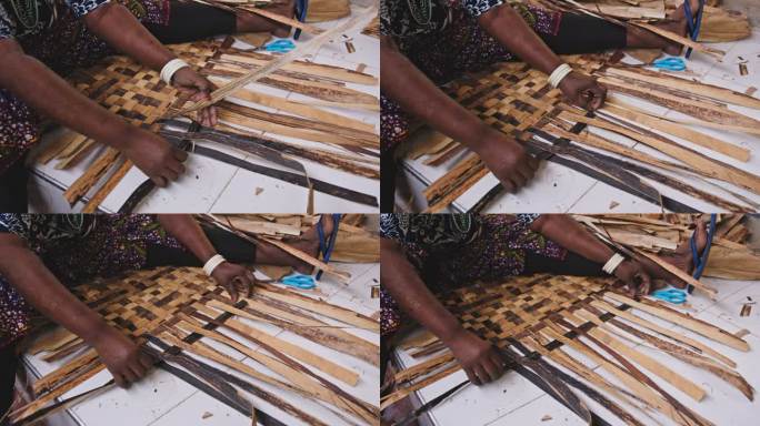 手持式女工匠制作工艺品的镜头。妇女在作坊里使用干棕榈叶。她在工作。