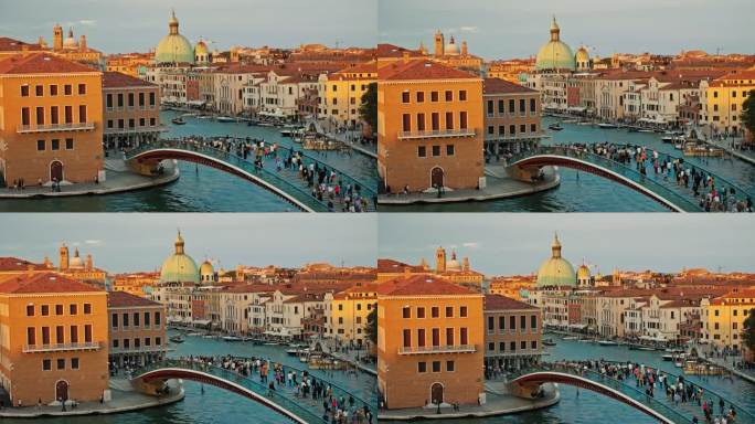 游客在威尼斯建筑物附近的宪法桥上走过大运河