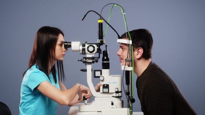 眼科医生使用现代设备检查一个人的眼睛，并为病人做激光视力矫正准备。眼科诊所的现代诊断设备。