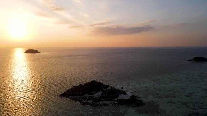 鸟瞰日出与阳光反射和戏剧性的天空与小岛，利比，沙卡通省，泰国