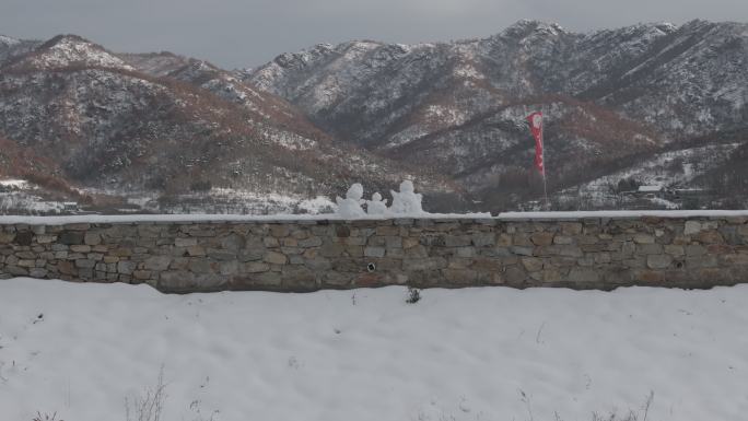 航拍威海里口山水库大坝堤岸上的三个小雪人