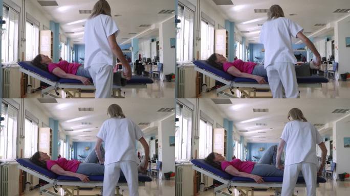在康复中心，一名女理疗师在和她的病人做腿部运动的手持剪辑