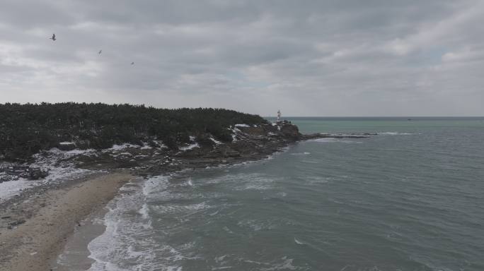 航拍威海双岛湾帽角海岬冬季雪后风光