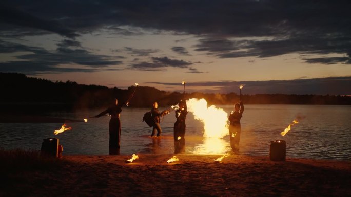 夏夜的艺术火表演，职业女演员旋转燃烧的火炬