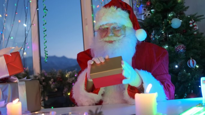 和蔼可亲的圣诞老人用甜蜜的微笑抚摸着大胡子的脸，欣赏着礼盒