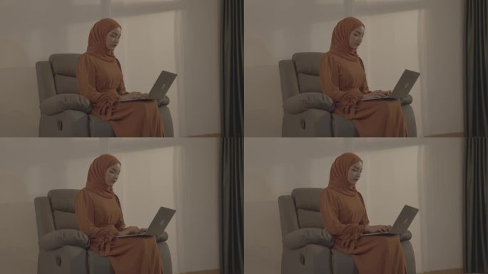 戴头巾的穆斯林妇女在家里使用笔记本电脑，人们信仰伊斯兰教的生活方式概念。