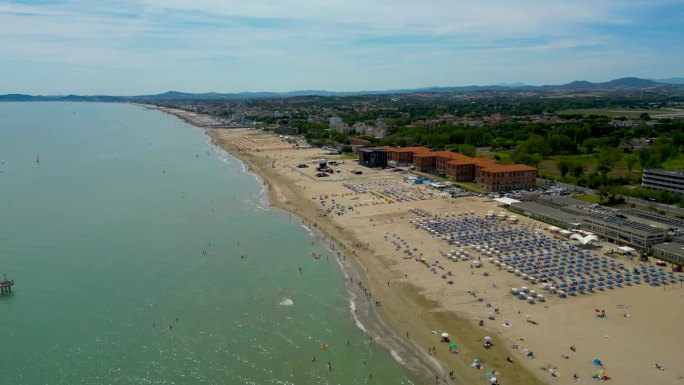 从飞行的无人机鸟瞰图人们聚集在意大利放松的海滩。暑假概念。