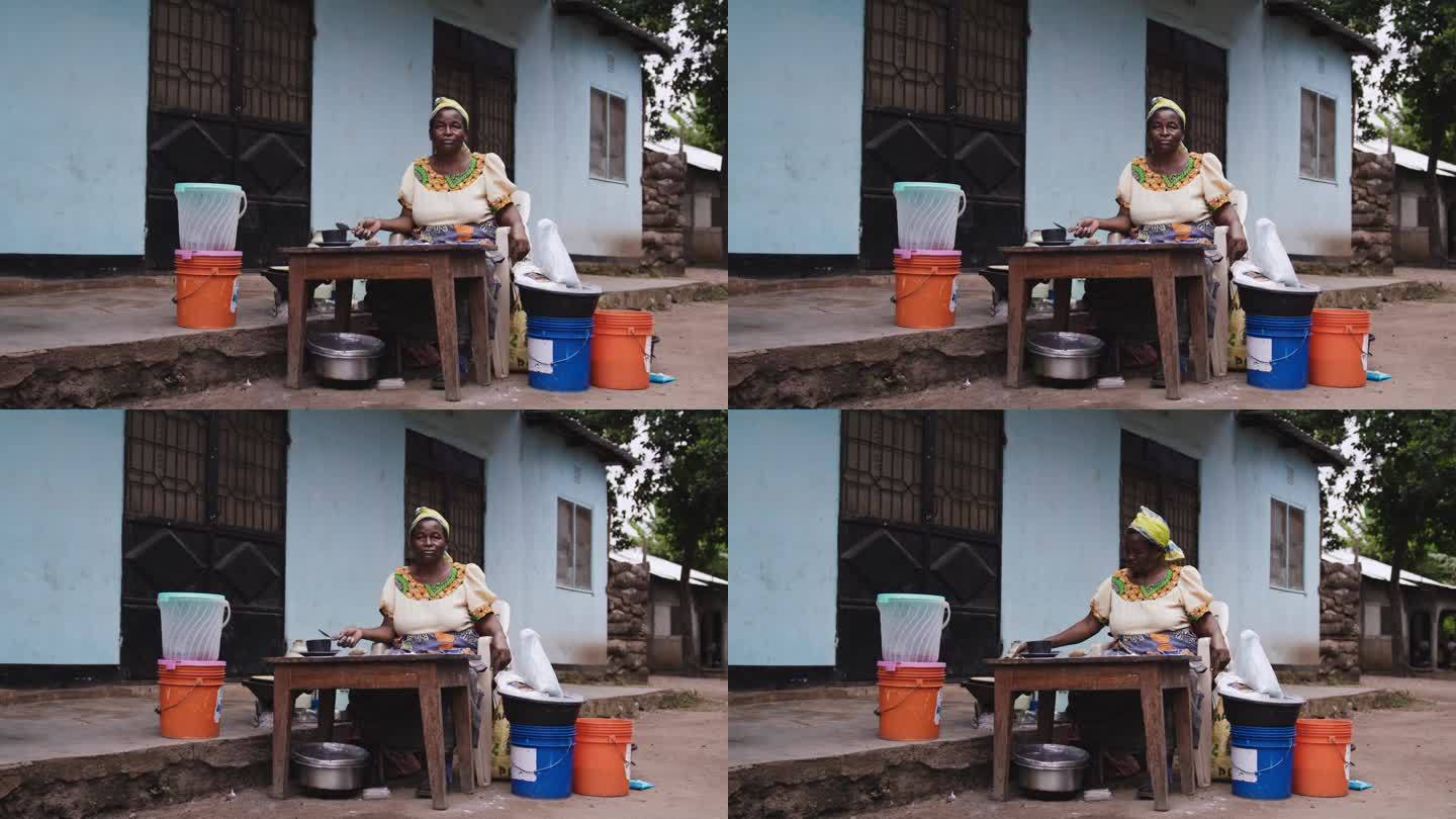 女性准备烹饪食物的慢动作。一个成熟的女人正坐在屋外。她穿着传统服装。