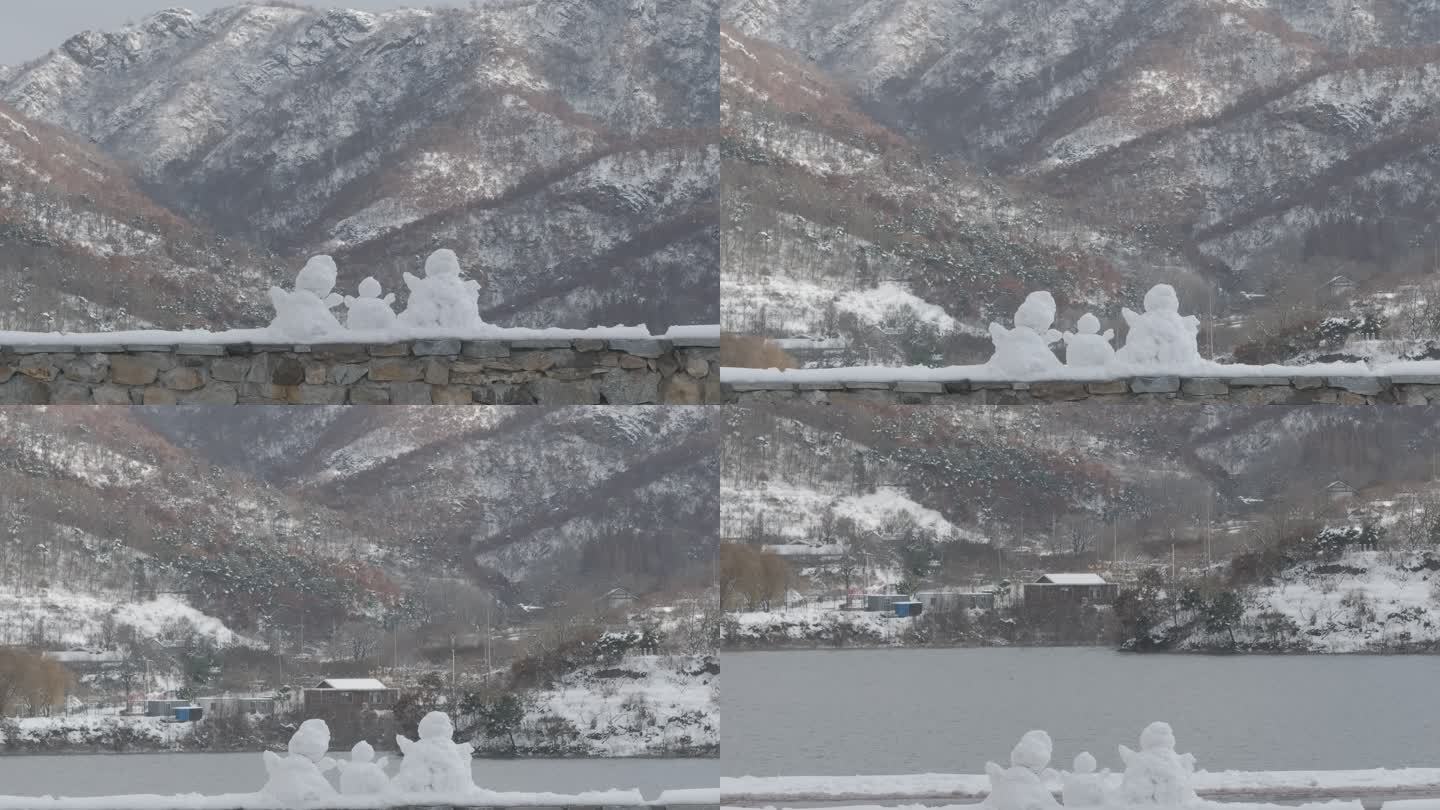 航拍威海里口山水库大坝堤岸上的三个小雪人