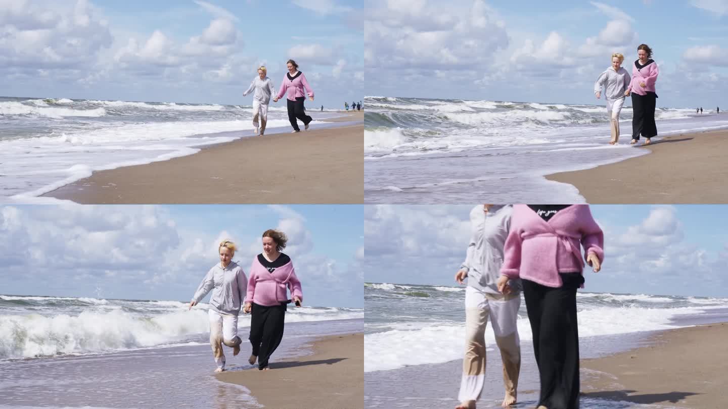快乐的妈妈和女儿沿着海边在沙滩和水里奔跑。