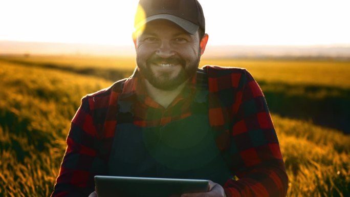 夏季农村田野里的男农民在收割。通过数码平板电脑从事小型业务。农业管理和会计新技术。经营销售天然产品。