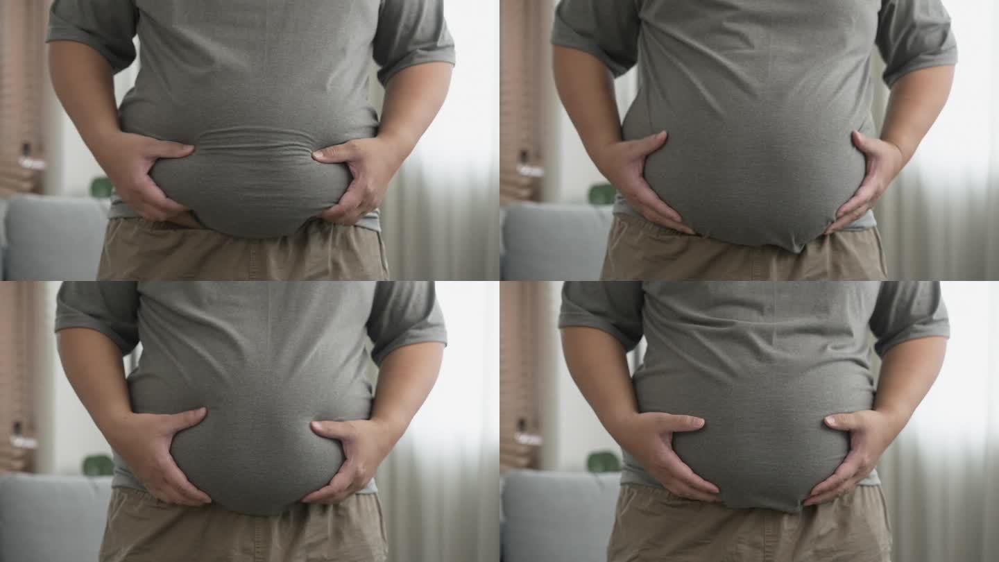 一个大男人用胖胖的肚子抚摸他的大肚子。超载的身体