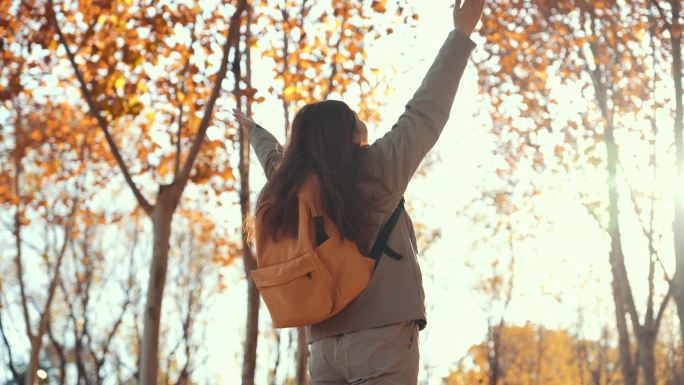 秋天的树林里，女人举起双手