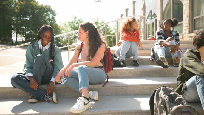 一群大学生坐在教学大楼的台阶上
