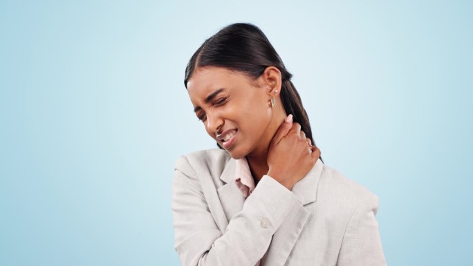 颈部疼痛，压力和工作室里患有关节炎的女商人，蓝色背景下的紧张或压力。肩、焦虑和女性企业家倦怠、骨质疏