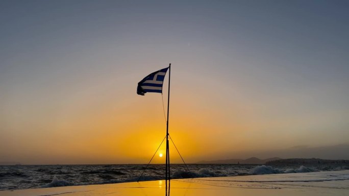 黄金时刻荣耀:希腊国旗，日落时的地中海海浪