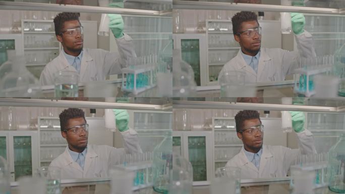 黑人男性科学家观察量杯中的化学反应