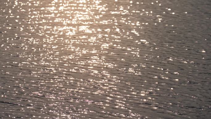 阳光洒在波光粼粼的湖水水面上