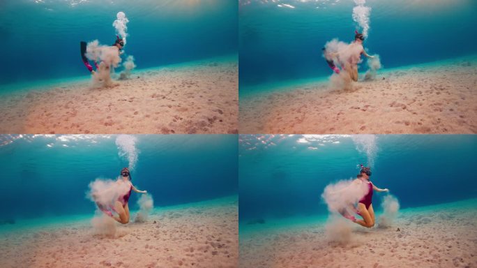 一名身穿粉色潜水服的女子在水下吹泡泡，享受着在热带海洋中游泳的乐趣