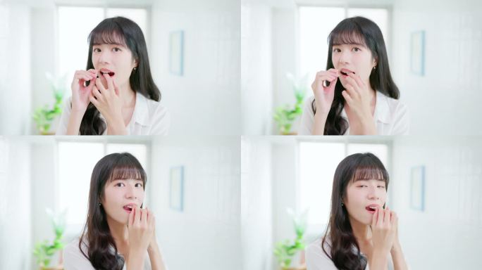 亚洲妇女愉快地用牙线剔牙