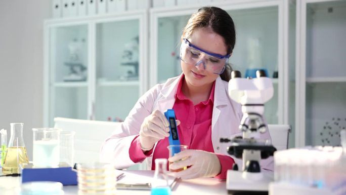 戴着安全眼镜的科学家实习学生用专业的pH计检查病人的尿液样本