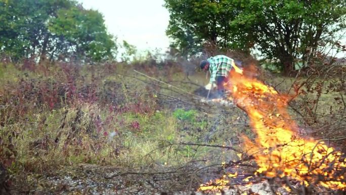 农民清理了他的土地，用火烧掉了干树枝。慢动作