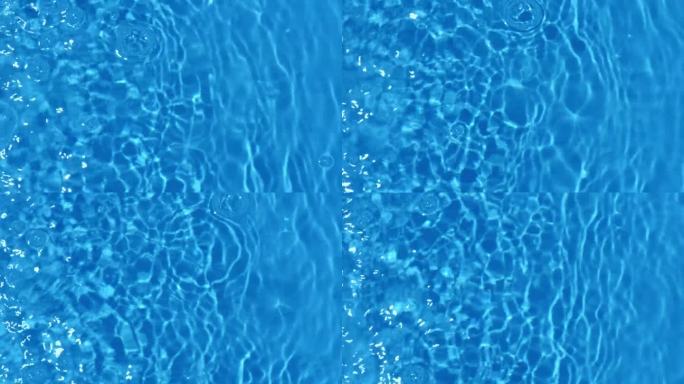 蓝蓝的水面上泛起涟漪。离焦模糊透明黑白彩色清晰平静水面纹理飞溅和泡沫。水波与闪亮的图案纹理背景。