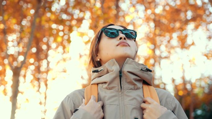 戴着反光太阳镜的女人正在看秋天的树林