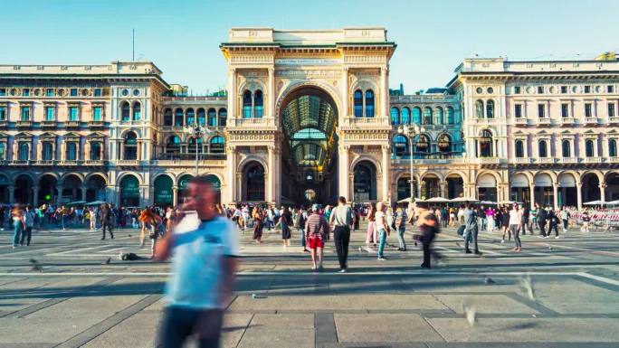 拥挤的游客在米兰大教堂广场漫步，在意大利米兰大教堂广场的维托里奥·伊曼纽尔二世画廊购买时尚品牌产品