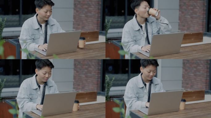 亚洲学生在网上学习，坐在街边的咖啡馆里，用笔记本电脑学习，喝着咖啡