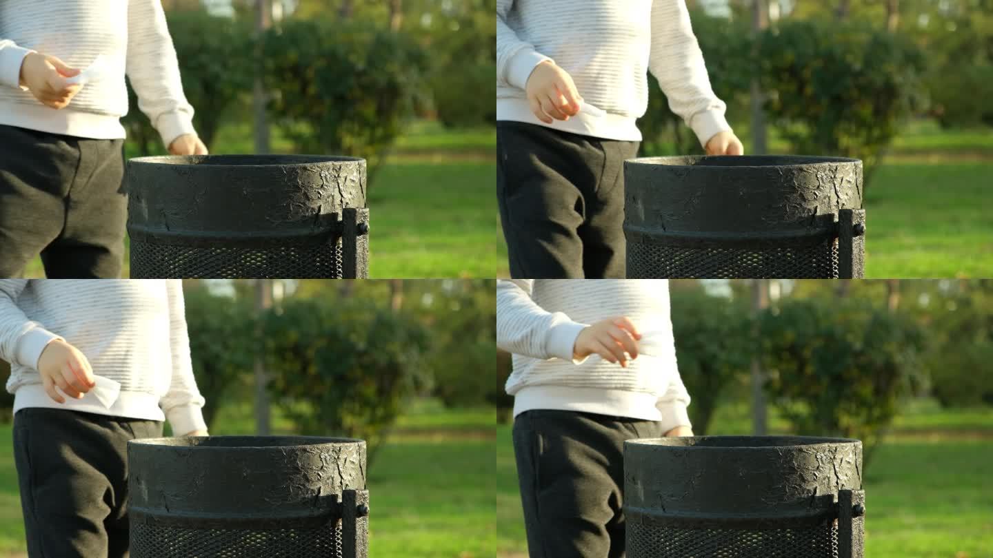 一个男孩在公园的垃圾桶里扔垃圾