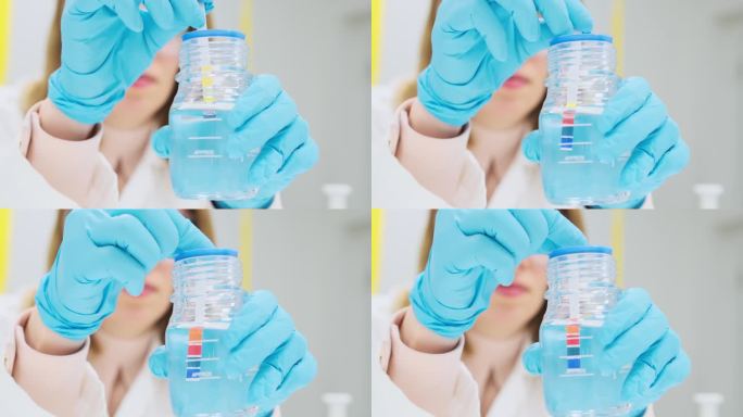 女化学家用指示纸测试溶液的pH值