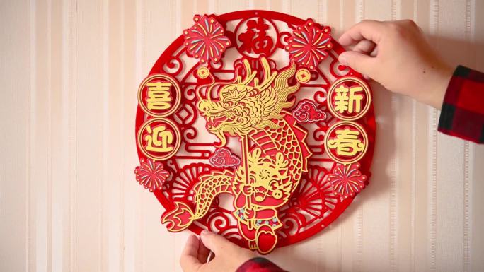 一名男子在一扇门上贴了一个中国新年的龙年装饰