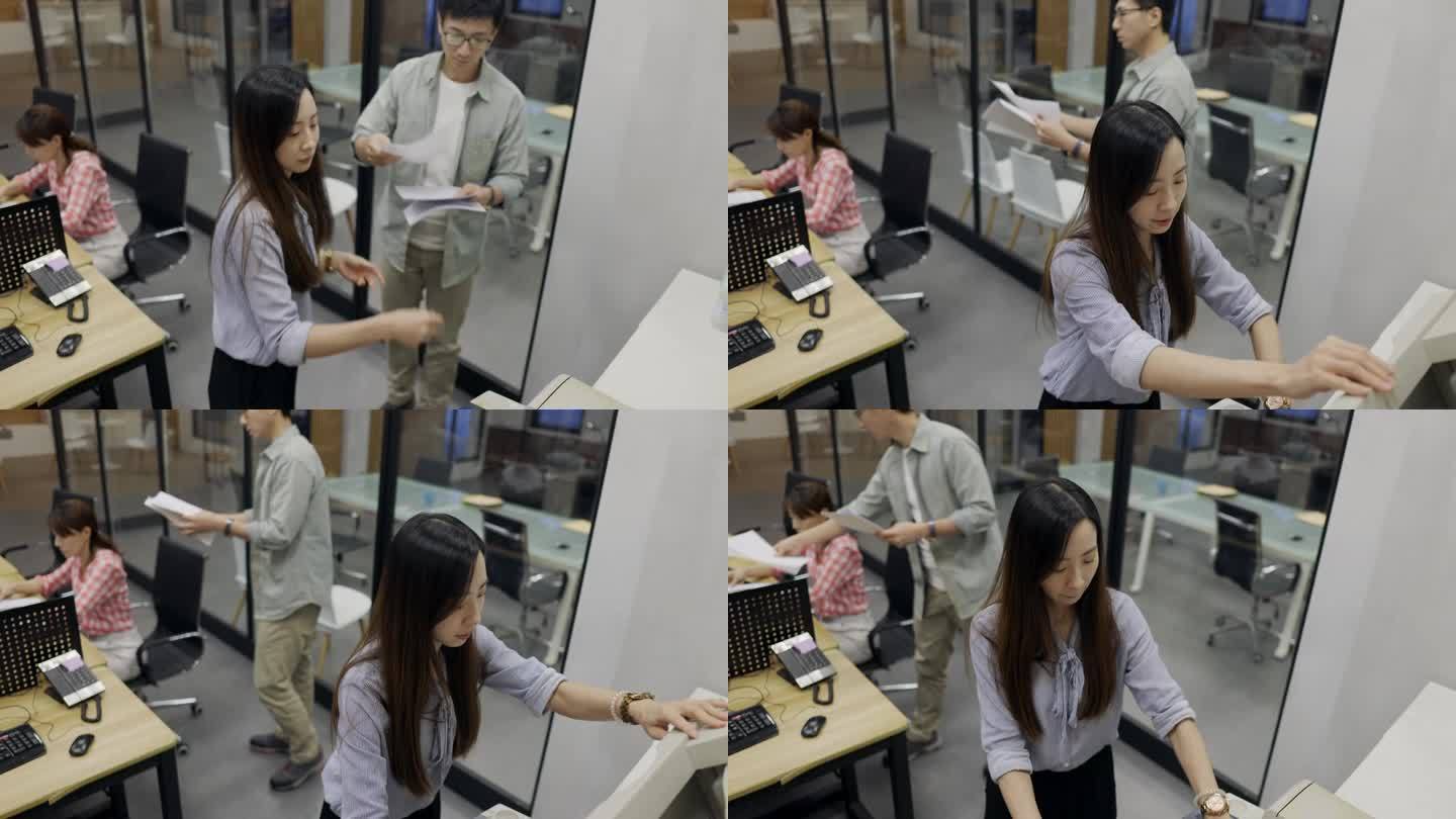在办公室里，一位亚洲女职员正在操作复印机，准备工作报告。