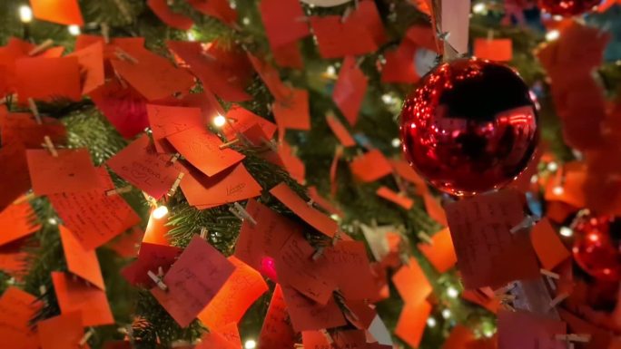 圣诞节和新年的外部装饰。绿色的树上装饰着红色的音符和球，闪烁的花环，明亮的灯。圣诞树。温馨的圣诞气氛