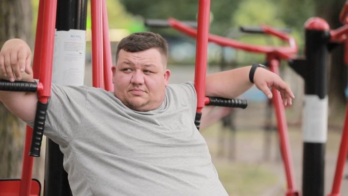 疲惫、肥胖、超重的男子在公园运动后休息。肥胖人群与运动