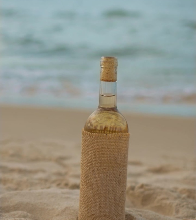 复古风格的战斗软木塞充满了白葡萄酒在沙滩上的水波散焦背景，垂直方向