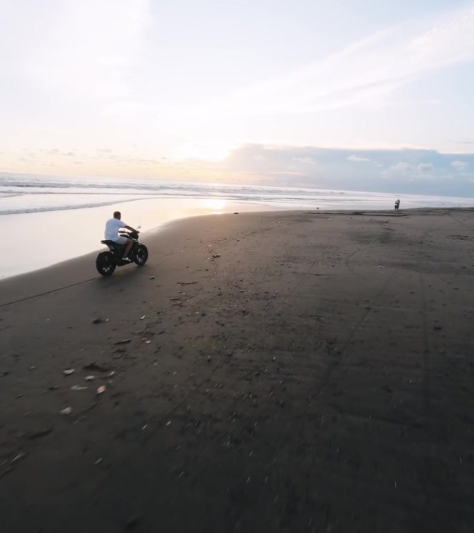 垂直视频。空中跟随fpv无人机骑自行车定制热带沙滩