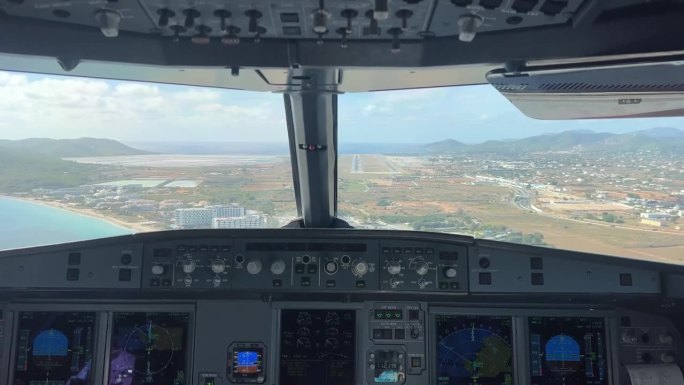在一个阳光明媚的早晨，从一架空客320的驾驶舱拍摄的在西班牙伊比沙岛机场进场和降落的照片。一个实时飞