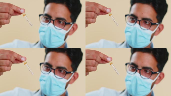 印度年轻的医生科学家男子小心翼翼地从移液器中滴下液体进行研究分析