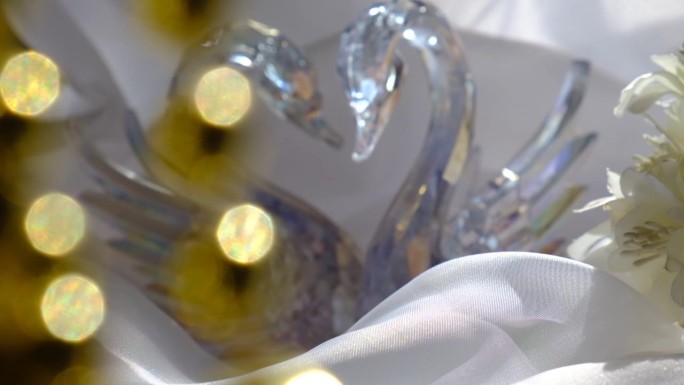 水晶天鹅夫妇对丝绸的背景，爱情，婚礼，蜜月的概念