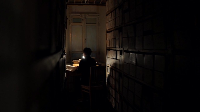 在黑暗的图书馆里，一名妇女在一排排书中翻阅旧书中的历史文献
