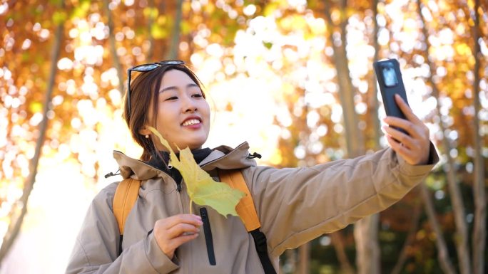 女子在秋天的树林里自拍