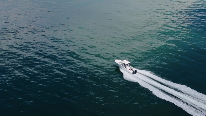 无人机看到一艘白色的船驶向蓝色的大海。高速移动的。