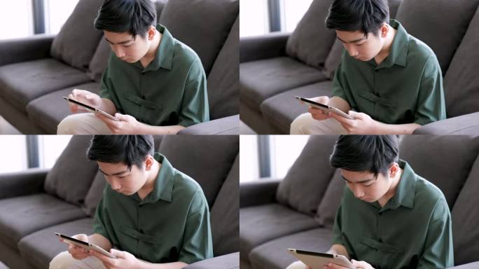 亚洲男孩独自坐在室内使用现代iPad访问社交媒体，孤立孤独的青少年专注于在线工作或游戏，男生反对社交