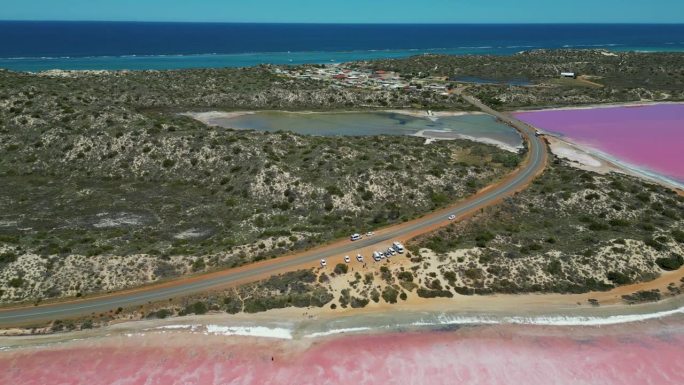 鸟瞰图俯瞰道路和粉红色湖的海岸线，赫特泻湖，西澳大利亚。背景是印度洋。