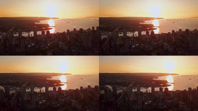高角度无人机飞行观看美丽的橙色夕阳照耀在温哥华的高楼大厦和反映在海里
